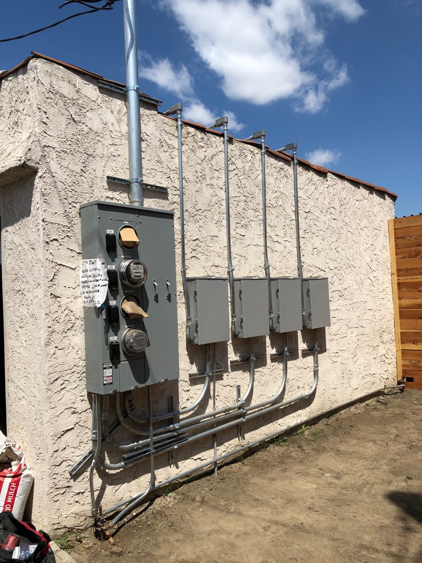 New multi-meter service and disconnect bank installed on a stucco building by JEM Electrical